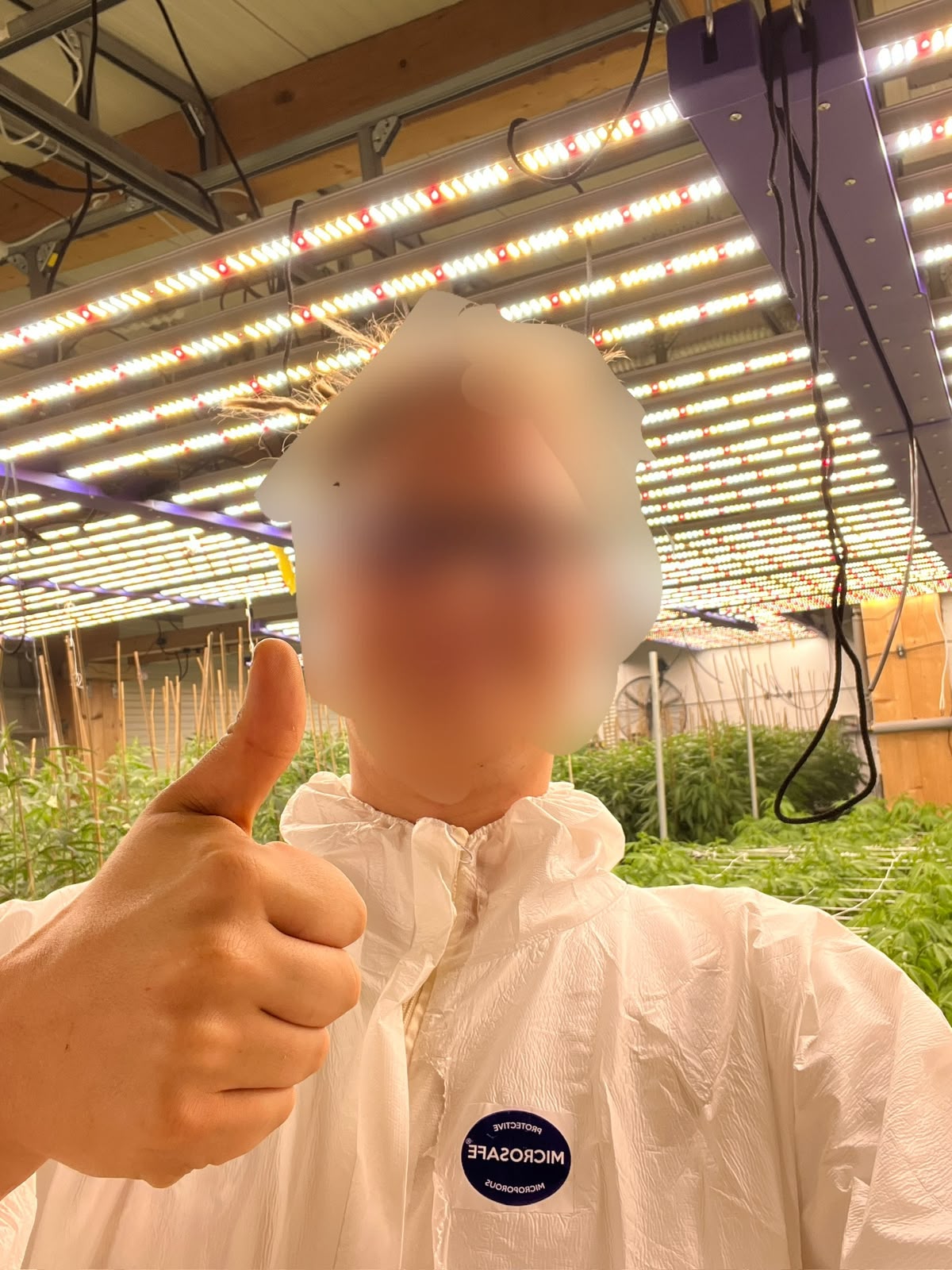Person in Schutzkleidung in einer Indoor-Anlage, Gesicht anonymisiert